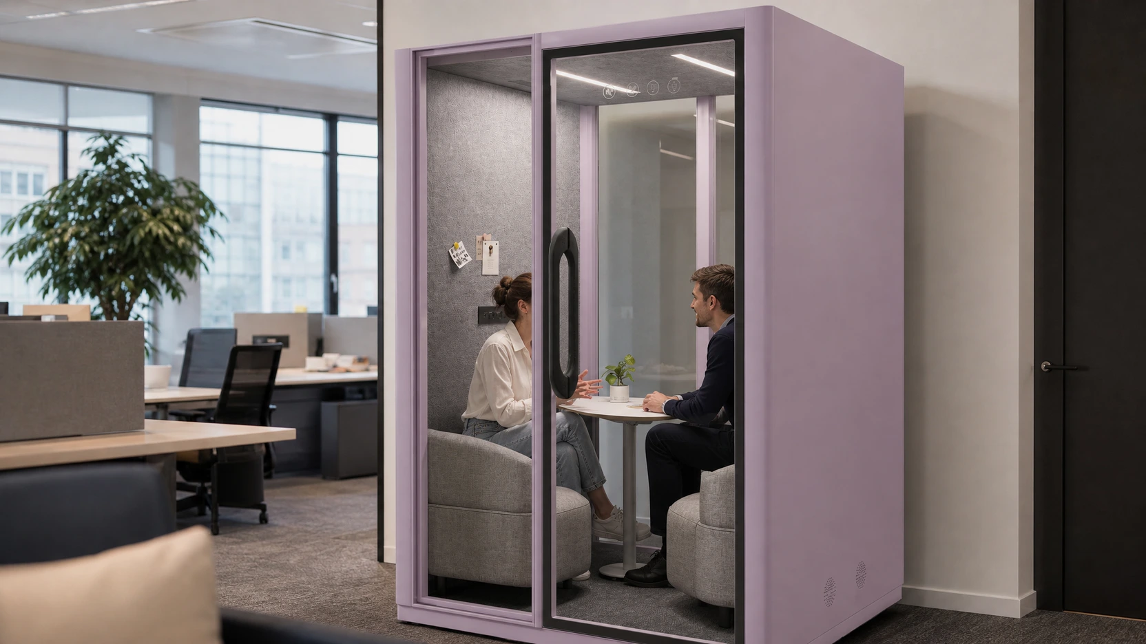 Two colleagues using a MOVUSH two-person pod for a focused conversation