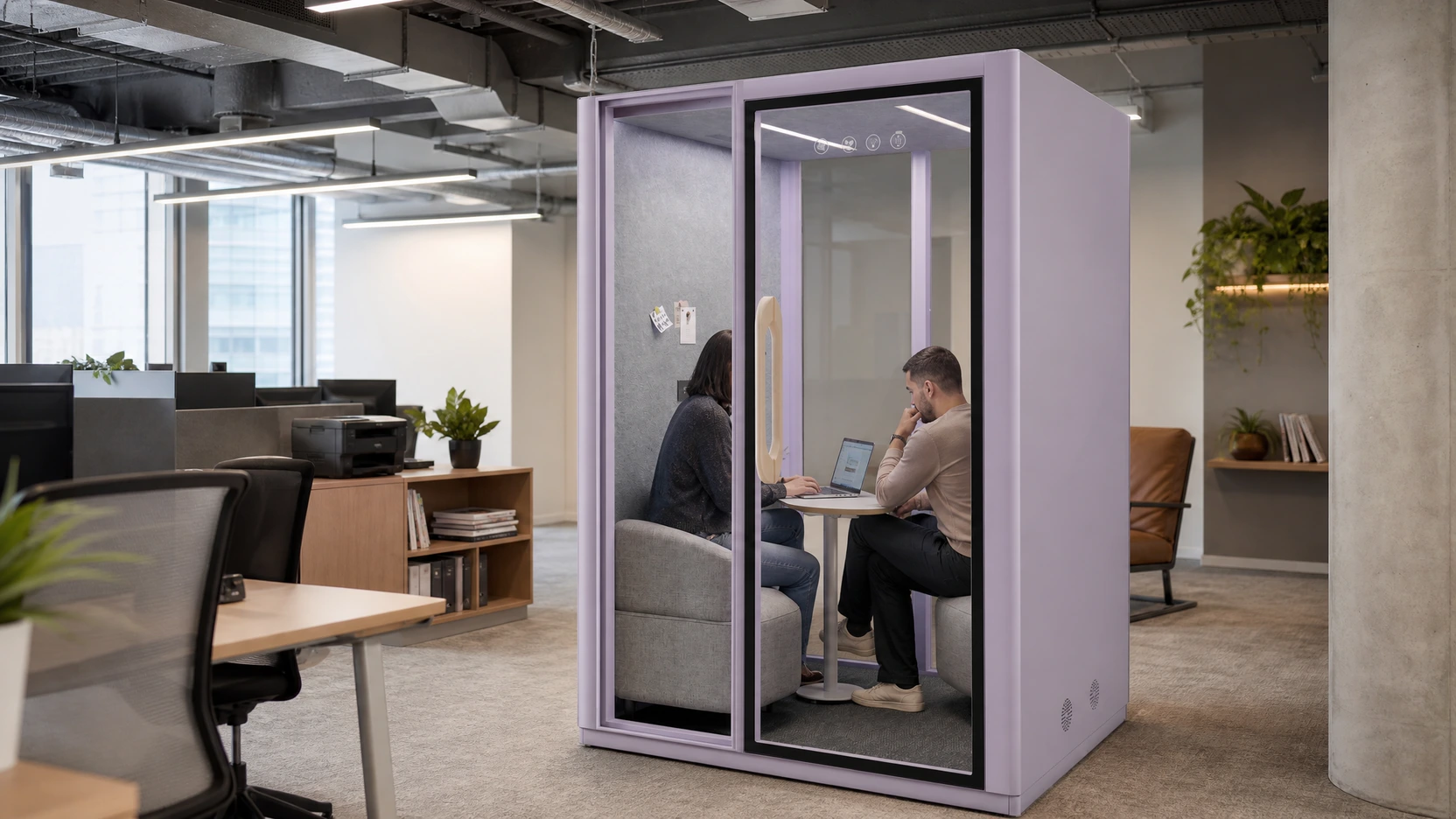 Two people using a MOVUSH pod with lighting, power, and meeting technology in view